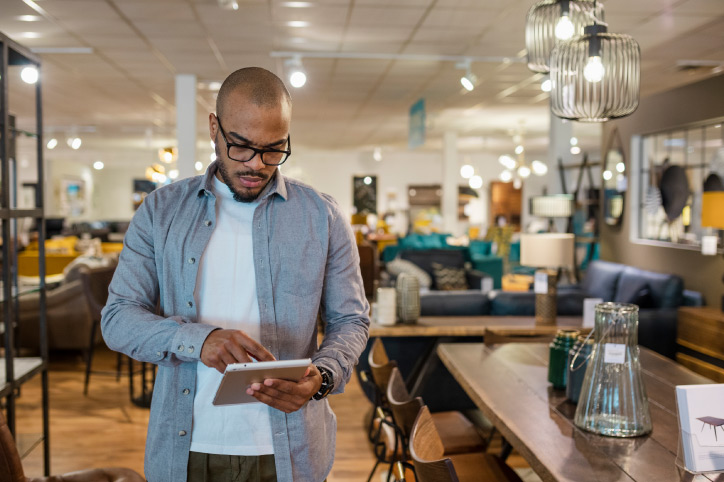 owner with a tablet considering flooring in a home goods store